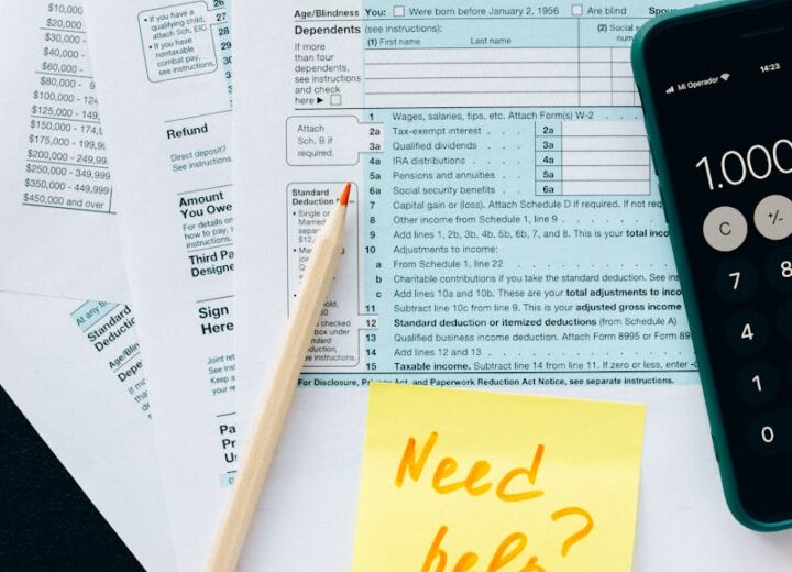 Close-up of tax forms with a calculator and a note asking for assistance.